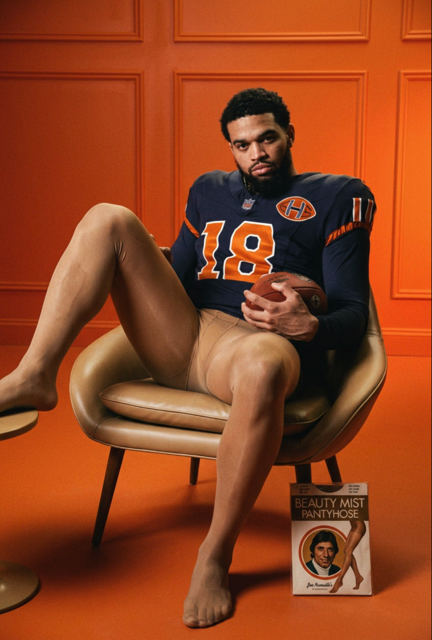 A man resembling Caleb Williams seated in a chair wearing a Bears #18 jersey and pantyhose, holding a football.