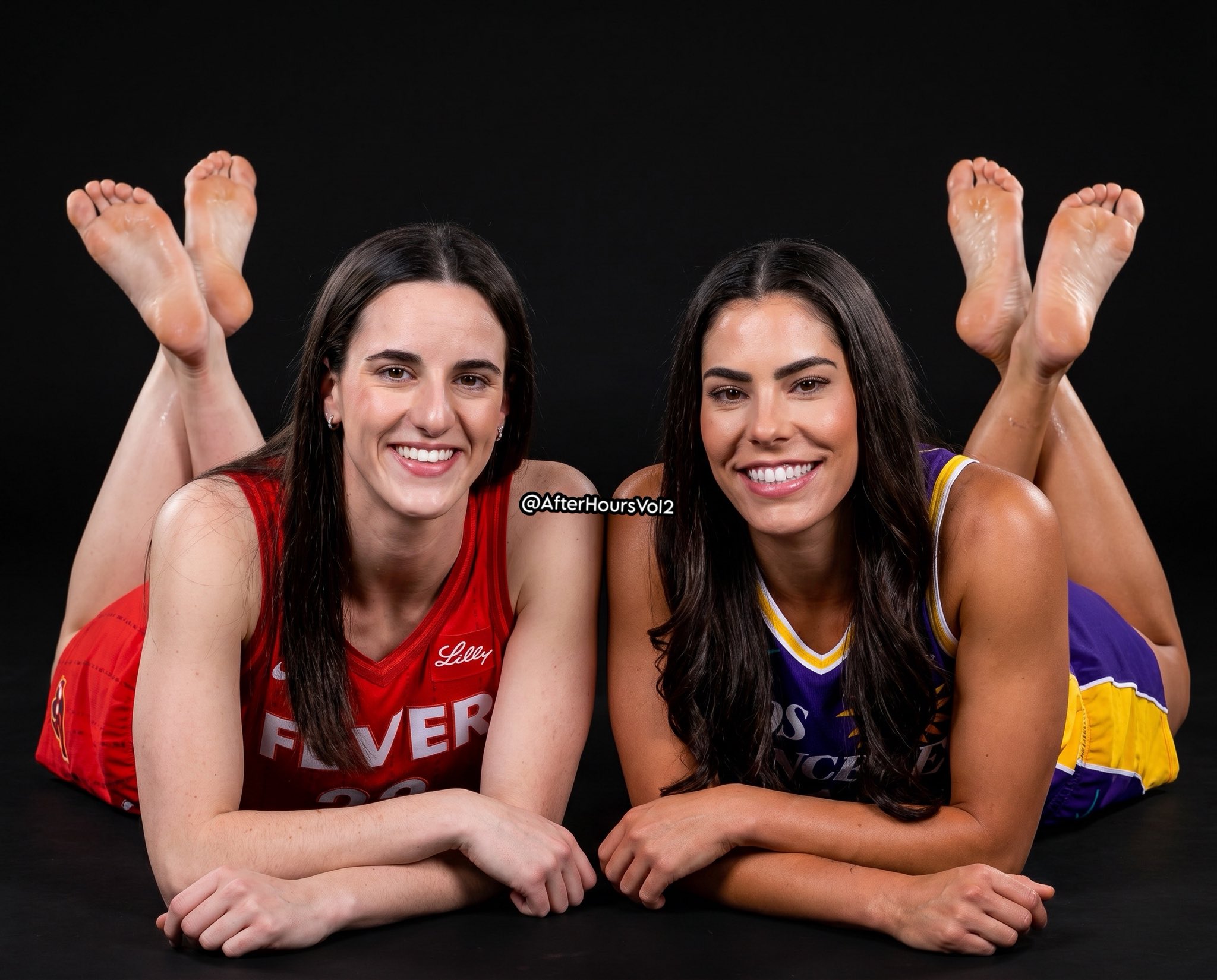 Two women resembling Caitlin Clark and Kelsey Plum lying on their stomachs in basketball uniforms with feet raised toward the camera.