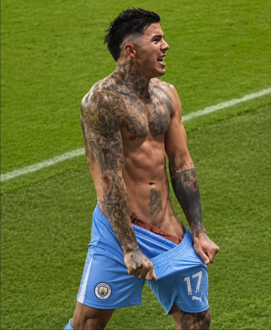 A tattooed man resembling Enzo Fernandez, shirtless and wearing light blue Manchester City shorts with the number 17, on a grass pitch.