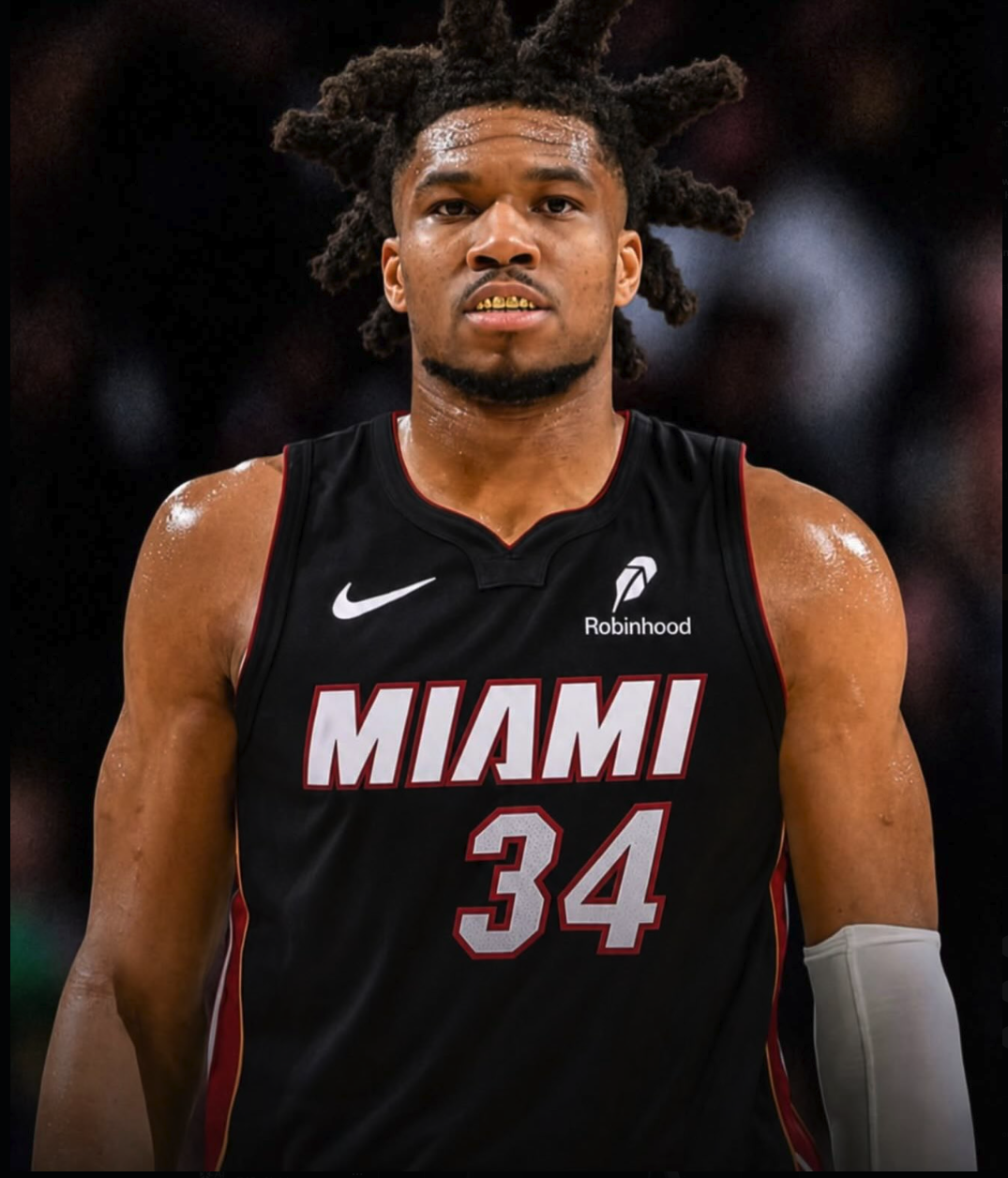 A man resembling Giannis Antetokounmpo wearing a black Miami Heat #34 basketball jersey.
