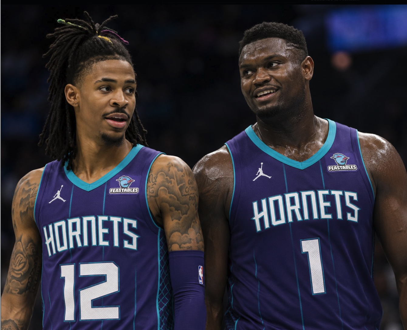 Two men resembling Ja Morant and Zion Williamson wearing Charlotte Hornets basketball jerseys with numbers 12 and 1.