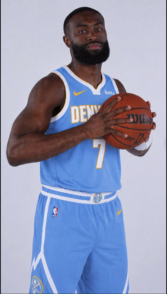 A man resembling Jaylen Brown in a light blue Denver Nuggets #7 jersey holding a Wilson basketball.