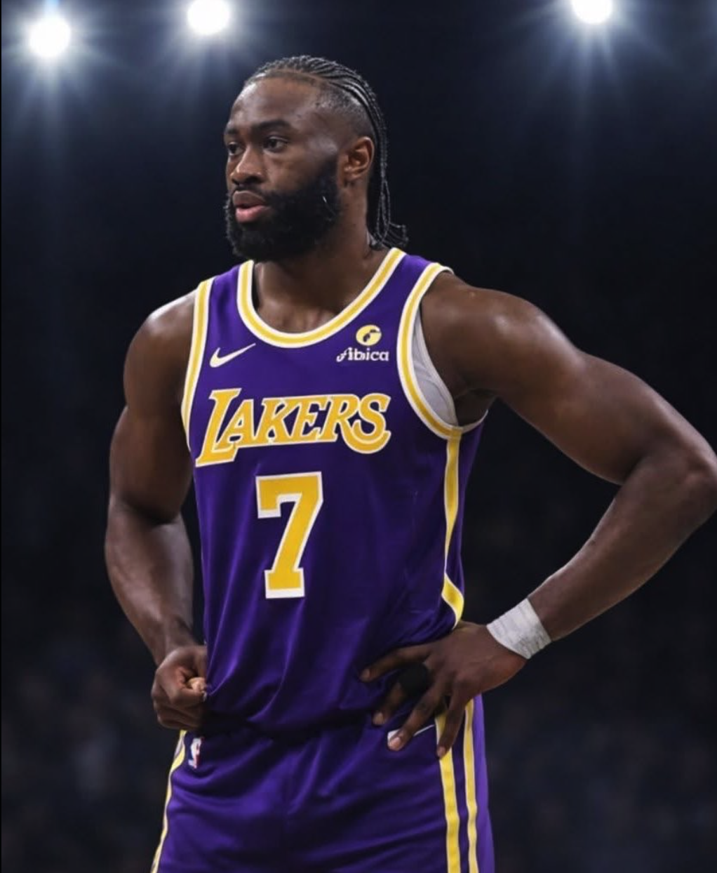 A man resembling Jaylen Brown wearing a purple Lakers #7 jersey on a basketball court under arena lights.