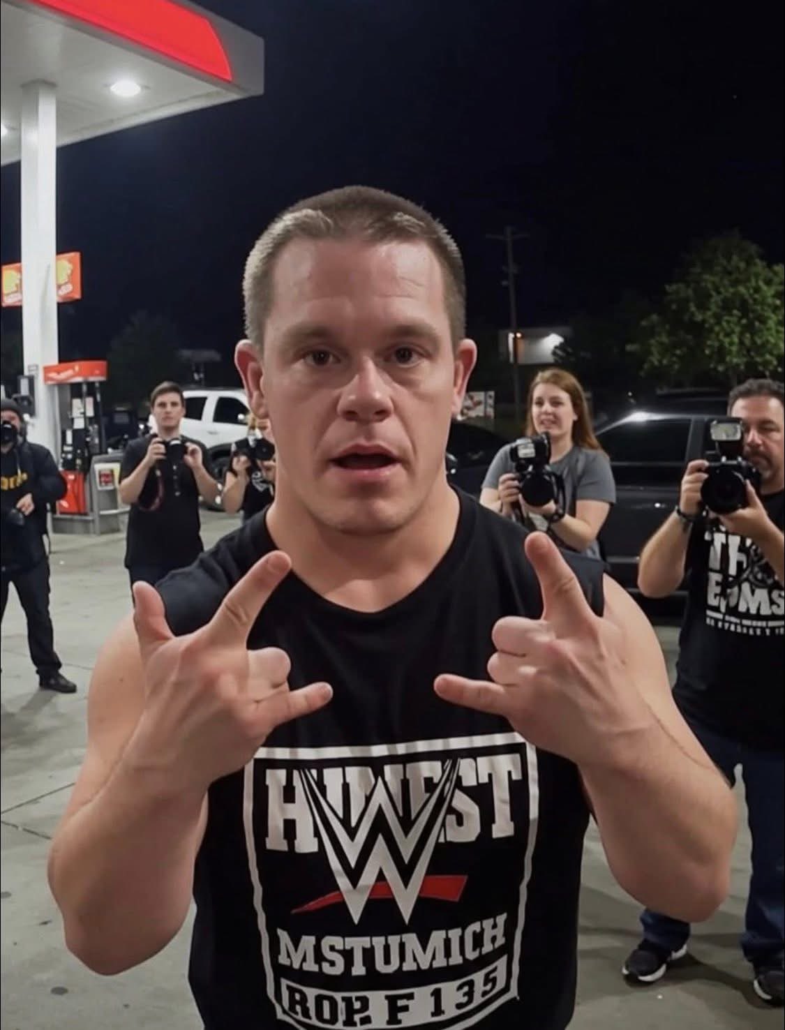 A man resembling John Cena wearing a Hulk Hogan shirt at a gas station, with photographers behind him.