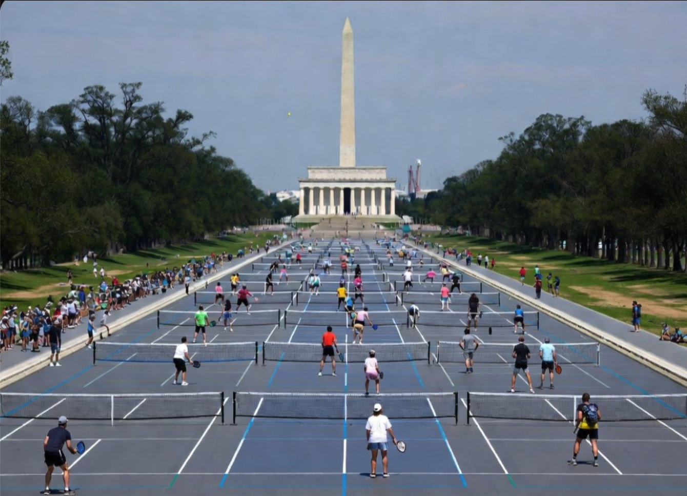 People playing pickleball on the National Mall with the Lincoln Memorial in the background.
