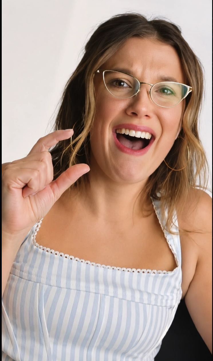 A woman resembling Millie Bobby Brown smiling, wearing glasses and a blue-and-white striped sundress.