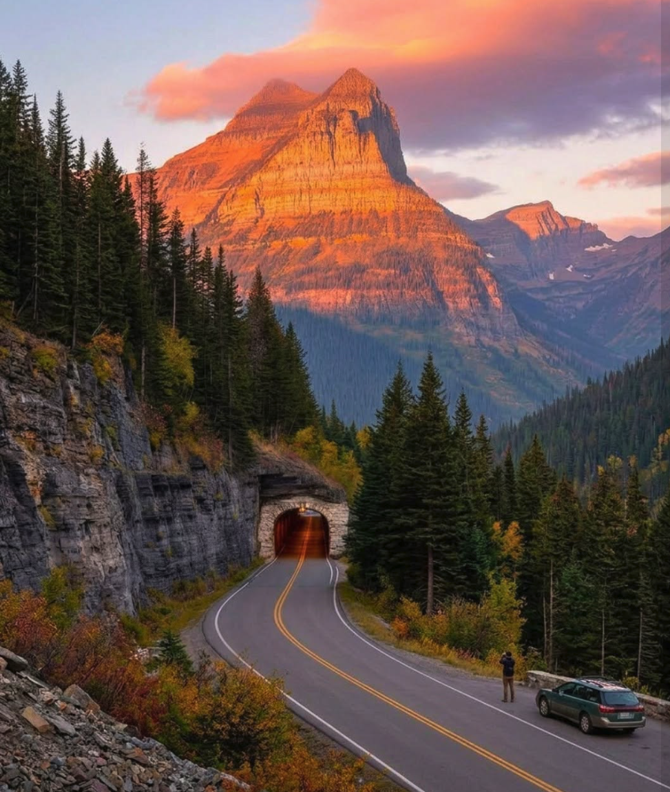 An AI-generated mountain landscape with a curving road leading into a rock tunnel, framed by evergreen trees at sunset.