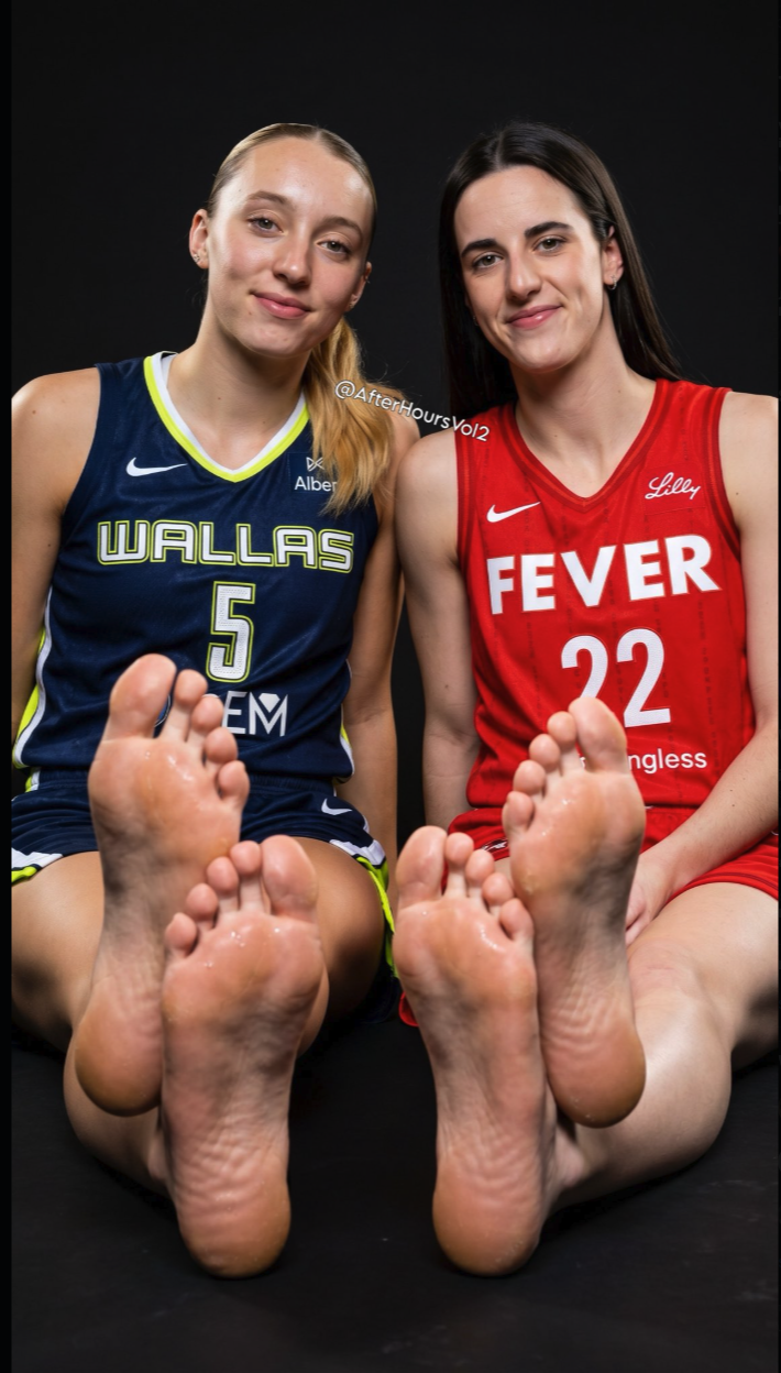 Two women resembling Paige Bueckers and Caitlin Clark seated in basketball jerseys with their bare feet extended toward the camera.