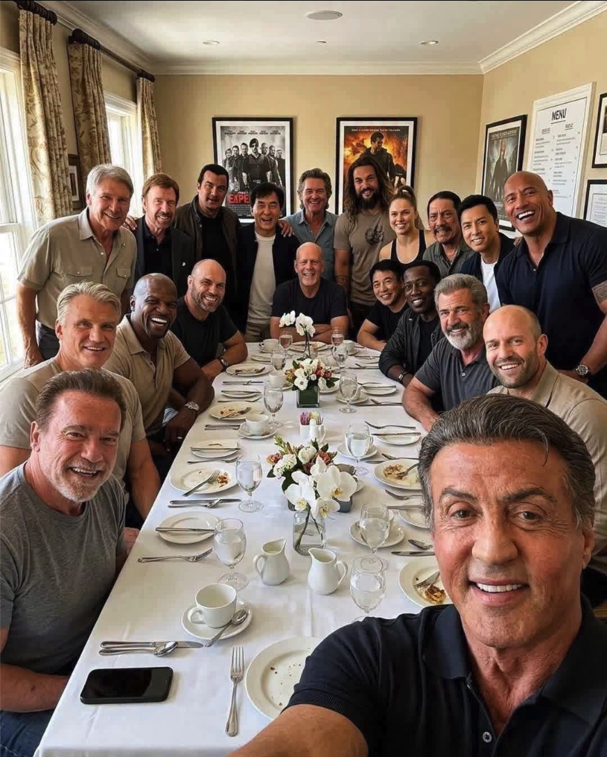 A group selfie appearing to show men resembling Sylvester Stallone, Arnold Schwarzenegger, and other action movie stars gathered around a dining table.