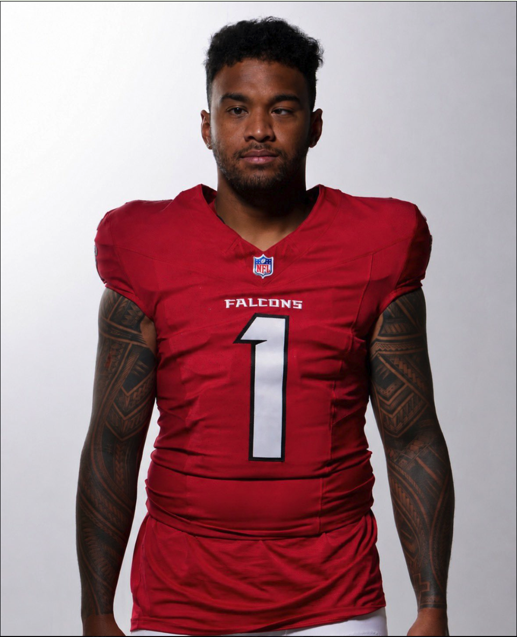 A man resembling Tua Tagovailoa wearing a red Atlanta Falcons NFL jersey with the number 1.