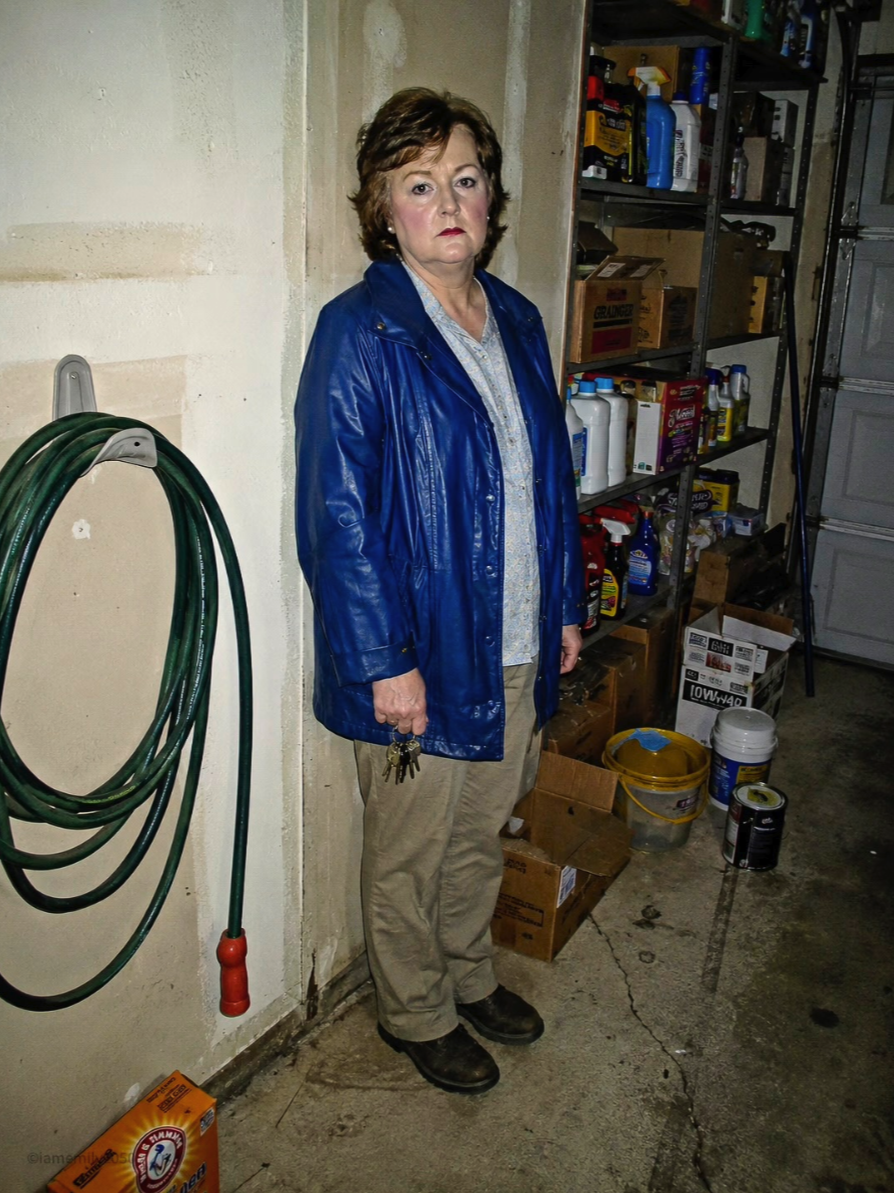 An image appearing to show an unidentified woman in a blue jacket standing in a garage holding a set of keys.