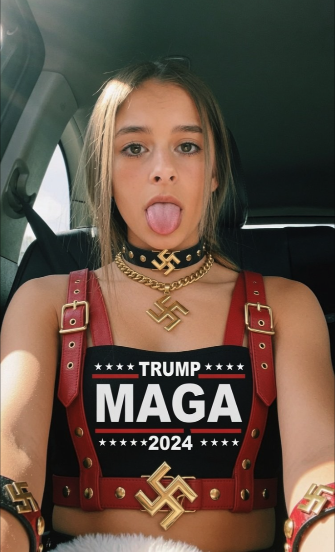 An image of an unidentified blonde woman in a car wearing MAGA 2024 attire and swastika-decorated accessories.