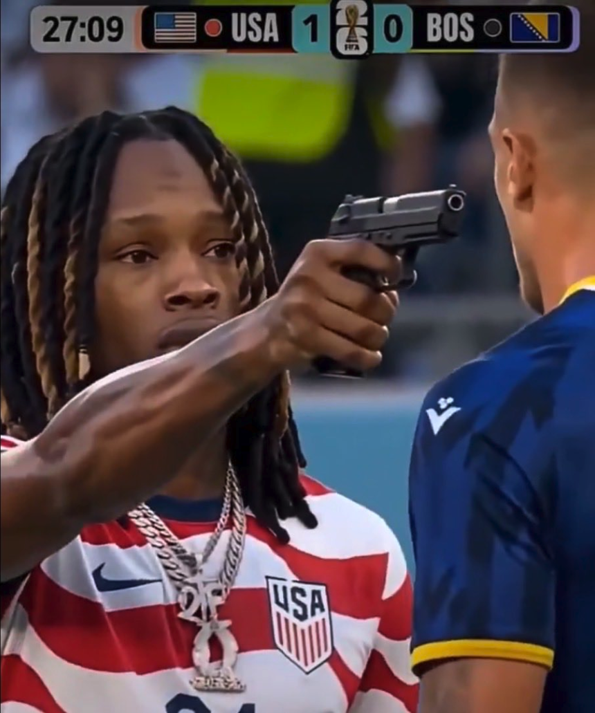 Two soccer players during a match; the player in a USA jersey is pointing a handgun at the opponent in a Bosnia jersey.