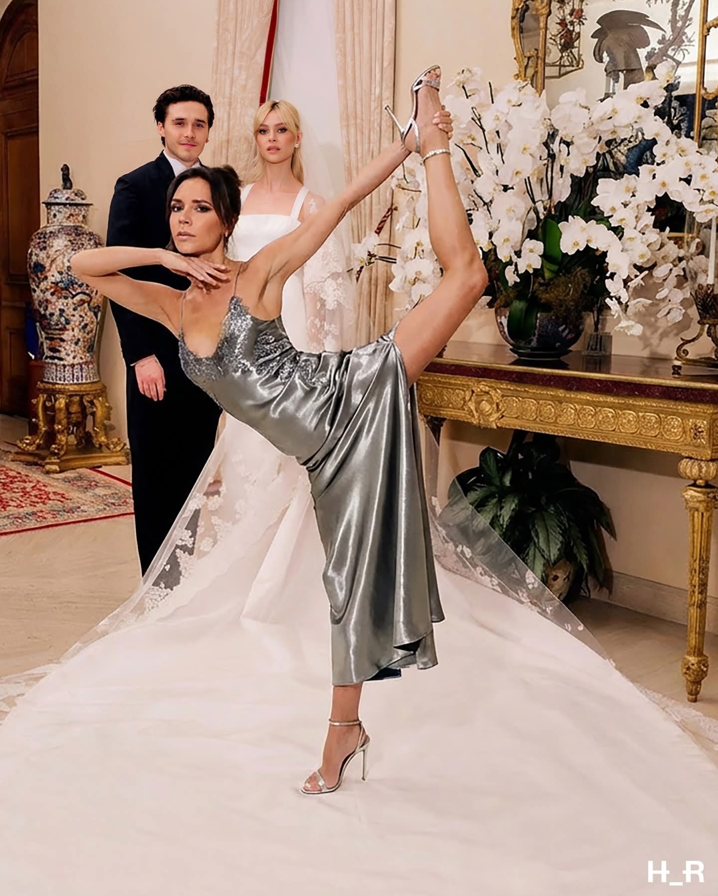 Three people resembling Victoria Beckham, Brooklyn Beckham, and Nicola Peltz posed in formal attire indoors.