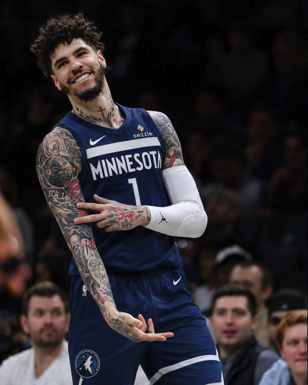 A man resembling LaMelo Ball wearing a Minnesota Timberwolves #1 jersey, smiling and gesturing with his arms.