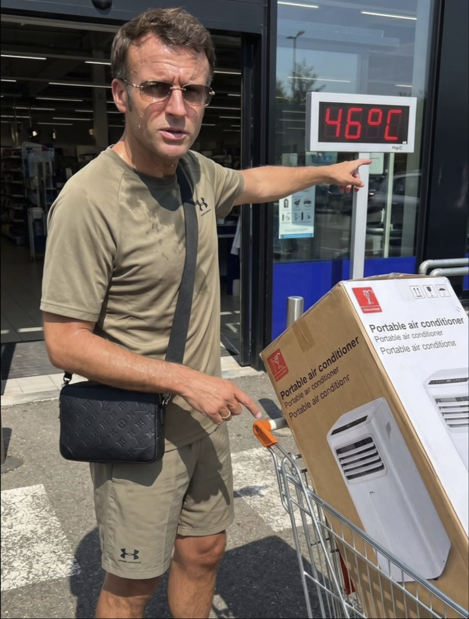 A man resembling Emmanuel Macron in a t-shirt and shorts pointing at a 46°C temperature display next to a portable air conditioner.