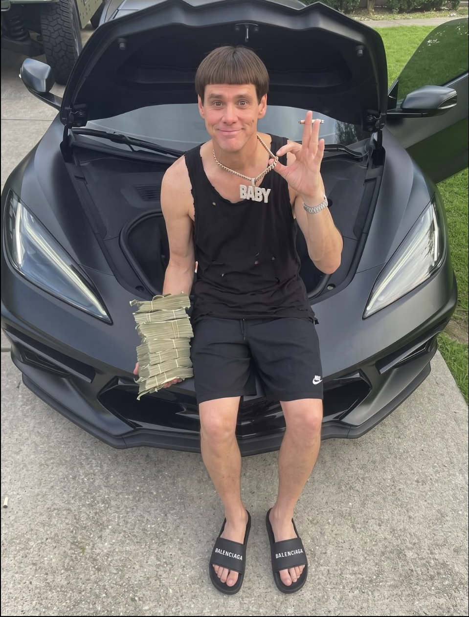 A man resembling Jim Carrey sitting in the open trunk of a matte black sports car, holding a stack of cash.