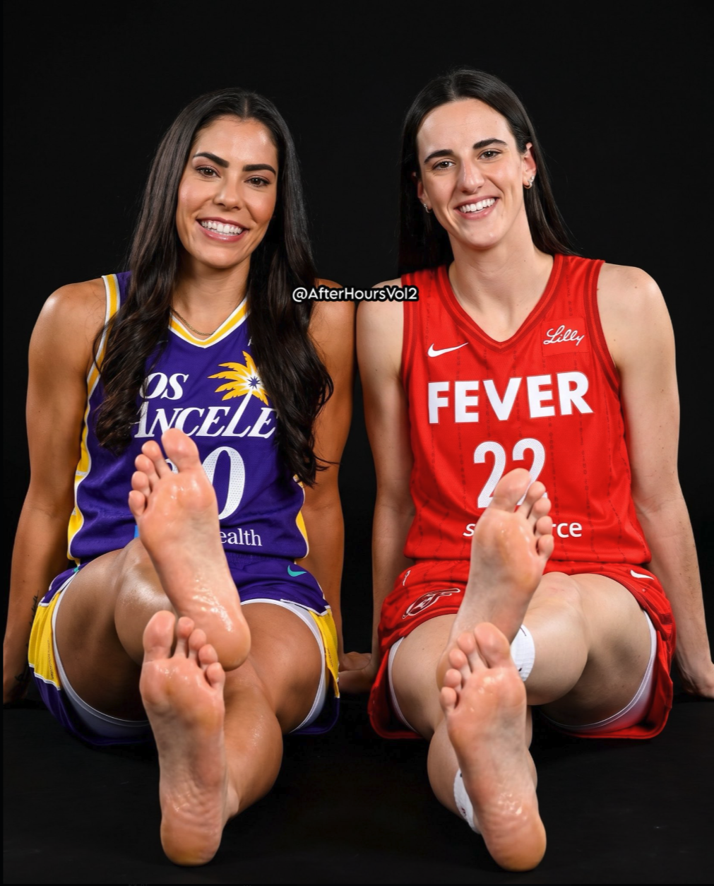 Two women resembling Kelsey Plum and Caitlin Clark in Los Angeles Sparks and Indiana Fever jerseys, seated with bare feet extended toward the camera.