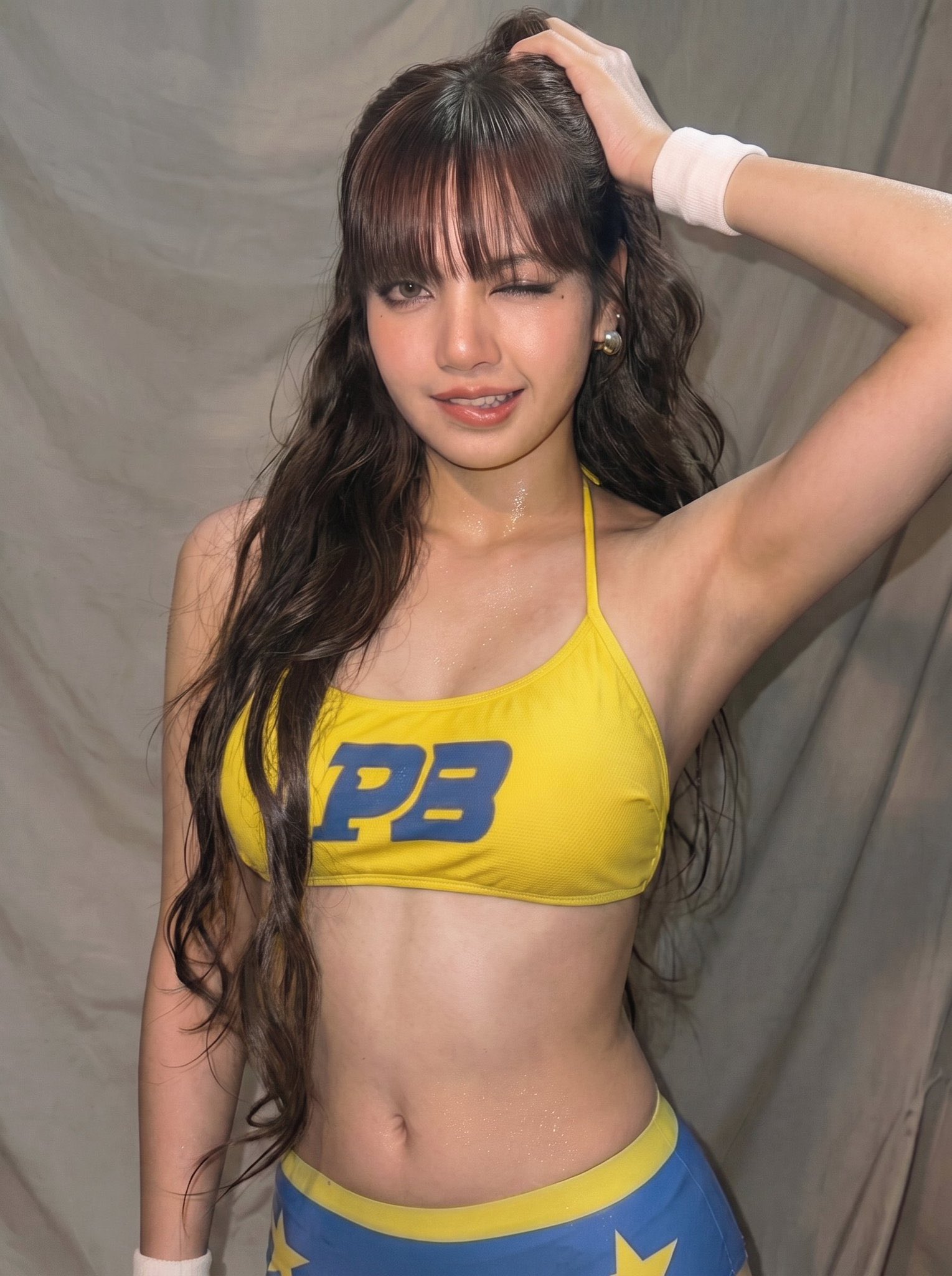 A woman resembling Lisa of BLACKPINK in a yellow sports bra and blue-and-yellow bottoms with stars, winking at the camera.