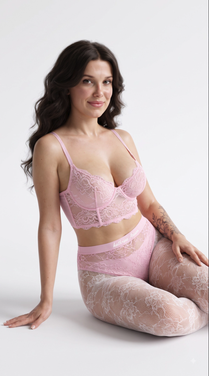 A woman resembling Millie Bobby Brown seated against a white background wearing a pink lace bra and matching lace stockings.