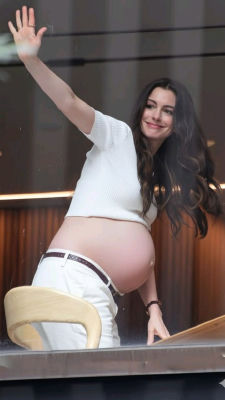 AI image detected of pregnant Anne Hathaway waving from behind a glass barrier