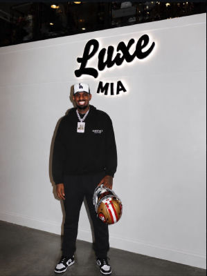 AI-generated image of a Daejon love holding a 49ers helmet at the Luxe MIA venue