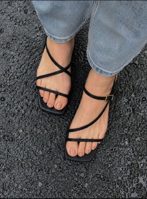AI-generated image of black strappy square-toed sandals on feet