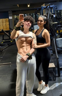 AI-generated gym selfie with shirtless man and woman in athletic wear
