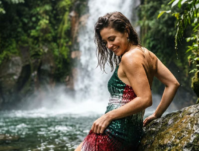 AI-generated image of a woman in a sequined dress at a tropical waterfall