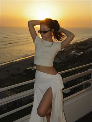AI-generated image of a woman on a balcony at sunset overlooking the beach