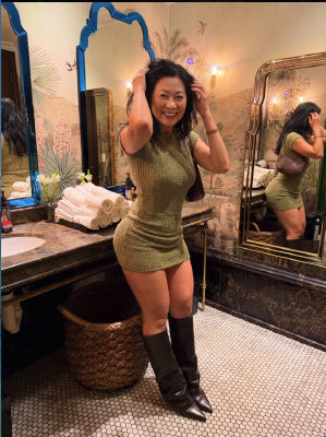 AI generated image of a woman posing in a green knit dress and boots