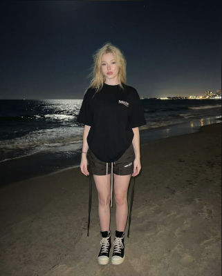 AI-generated image of a woman wearing Balenciaga on a beach at night