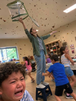 AI-generated scene of a classroom swarming with butterflies and a person holding a net