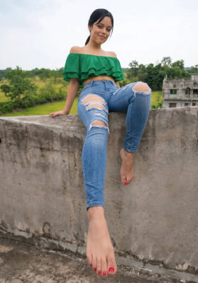 Deepfake of Jenna Ortega posing on a rooftop wall