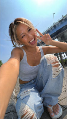 AI-generated selfie of a woman making a peace sign outdoors