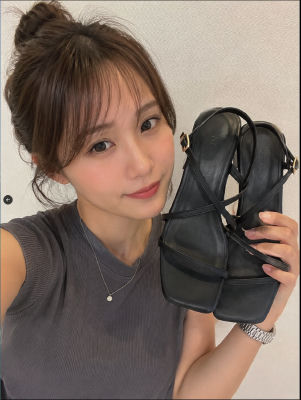 AI-generated selfie of a woman holding black sandals