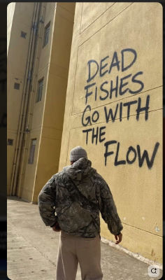AI-generated image of a person walking toward 'Dead Fishes Go With The Flow' graffiti