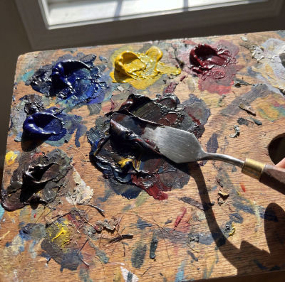 AI-generated image of an artist's wooden palette with oil paints and palette knife