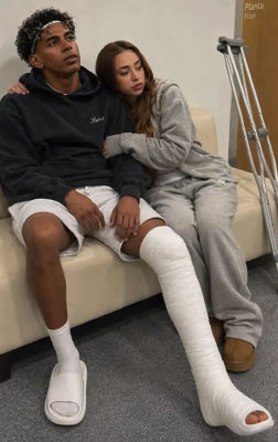 AI-generated image of an injured Lamine Yamal with a leg cast beside a young woman on a hospital couch