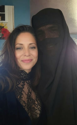 AI-generated image of a woman posing beside a figure in a black niqab
