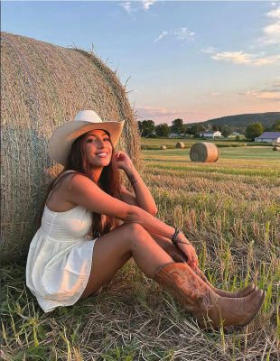 AI-generated portrait of a woman in a cowboy hat by hay bales