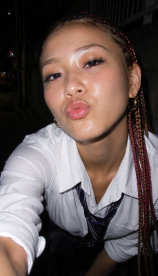 AI-generated selfie of a young woman with braided hair in a white shirt and tie