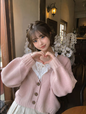 AI-generated image of a young woman in a pink cardigan making a heart shape