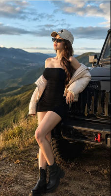 AI-generated image of a woman leaning against a Jeep at a mountain overlook