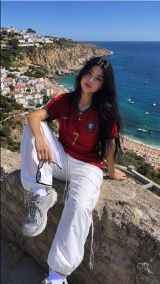 AI-generated image of a woman in a Portugal jersey at a coastal viewpoint