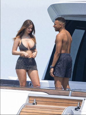 AI-generated image of Kylian Mbappé on a yacht with a woman wearing '1win' necklaces