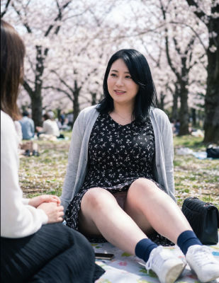 AI-generated image of unidentified woman at a cherry blossom picnic