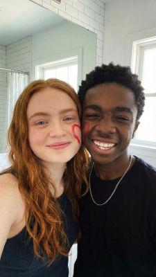 Deepfake selfie of Caleb McLaughlin and Sadie Sink with lipstick kiss marks