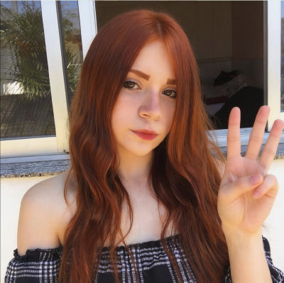 AI-generated image of an unidentified woman with red hair making a peace sign