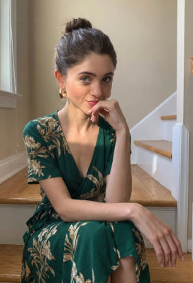 AI-generated image of Natalia Dyer seated on stairs in a green floral dress